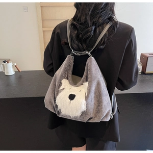 Detail of grey velvet backpack featuring a plush dog face design and metal ring strap