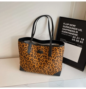 Detailaufnahme der Tragetasche mit Leopardenmuster, schwarzen Griffen und Ecken