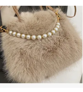 Dettaglio borsa in ecopelliccia con manico di perle eleganti e rifiniture dorate