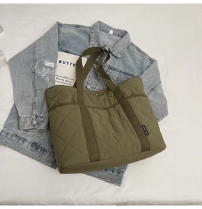 Gros plan sur le sac fourre-tout matelassé vert foncé avec motif à losanges et étiquette