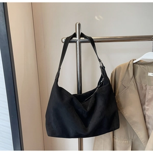 Detail der minimalistischen schwarzen Hobo-Tasche aus Mattleder mit verstellbarer Schnalle