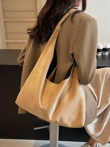 Grand sac cabas minimaliste en daim camel pour femme présenté dans un café cosy