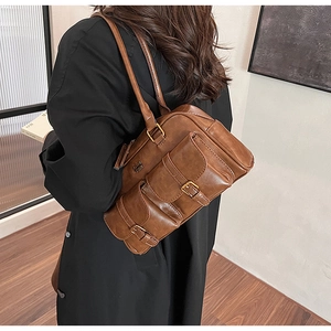 Detail view of the vintage brown faux leather shoulder bag with embossed CVM TOR logo