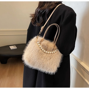 Dettaglio borsa a secchiello in peluche beige con manico di perle e tracolla in pelle