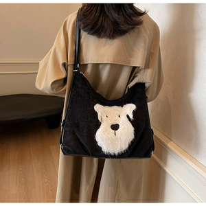 Close-up of black corduroy tote bag featuring a plush schnauzer dog patch on the back