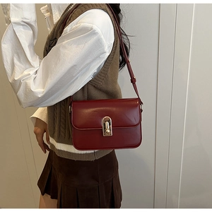 Detailed side view of the vintage red leather square bag with elegant gold metal buckle