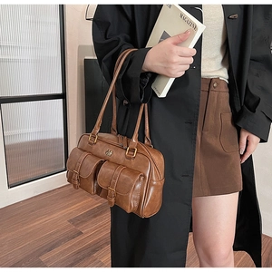 Detailed close-up of brown faux leather vintage shoulder bag with metal buckle pockets