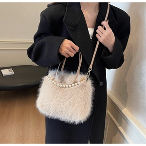 Dettaglio borsa beige in ecopelliccia con bordo di perle e tracolla rimovibile elegante