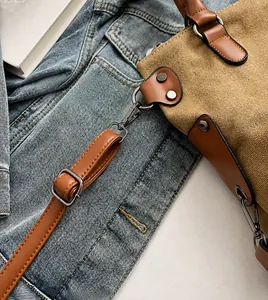 Dettaglio borsa tote in tela con tracolla regolabile in pelle e ganci in metallo