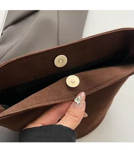Detailaufnahme der hochwertigen Magnetschnalle und der matten Wildlederstruktur der Tasche
