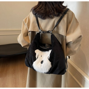 Detail of a casual black corduroy tote with a plush white schnauzer dog appliqué design