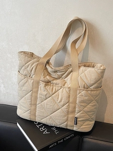Sac fourre-tout matelassé beige avec surpiqûres en losange et poche latérale pratique