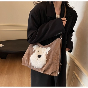 Detailed view of the brown suede shoulder bag featuring a white plush dog applique