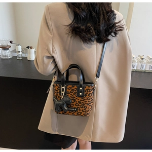 Détail du sac seau léopard avec breloque chien noir et rivets métalliques décoratifs