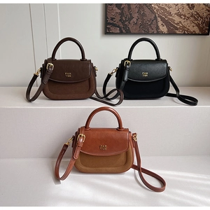Detailed view of three minimalist leather handbags in coffee, black and caramel brown colors