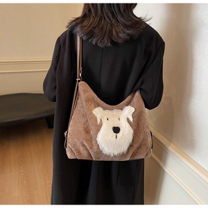 Detail of a brown corduroy tote bag with white schnauzer patch worn by a model