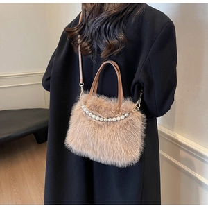 Dettaglio borsa a secchiello in peluche beige con manico di perle e cuoio