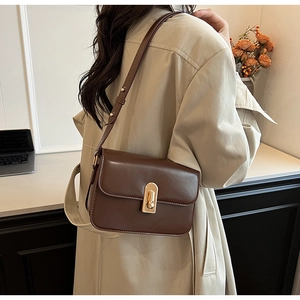 Brown vintage square shoulder bag with gold vertical twist lock on a smooth flap cover