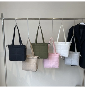 Close-up of quilted nylon tote bags in six colors hanging on a metal rack
