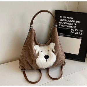 Detail showing the brown velvet texture and plush dog applique on the backpack