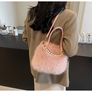 Dettaglio della borsa rosa in ecopelliccia con manico di perle e texture morbida
