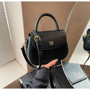 Detailed view of black pebbled leather handbag with gold hardware and PAN TOR logo