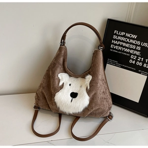 Detailed view of the brown corduroy tote with a cute white plush puppy appliqué detail