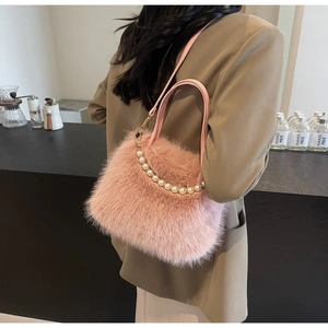 Dettaglio borsa a secchiello in ecopelliccia rosa con eleganti perle grandi sul manico