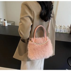 Dettaglio borsa a secchiello in peluche rosa con manico di perle e tracolla in pelle