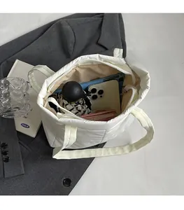 Spacious interior of white quilted tote bag showing phone, umbrella and wallet storage