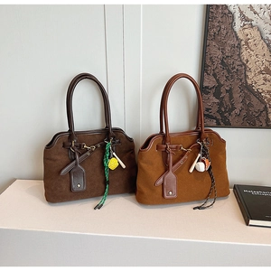 Detail of vintage matte leather tote bags with baseball charms and strap accents