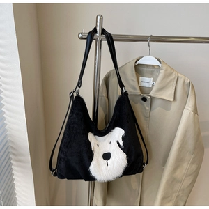 Detail of black corduroy tote bag featuring a plush white schnauzer puppy patch