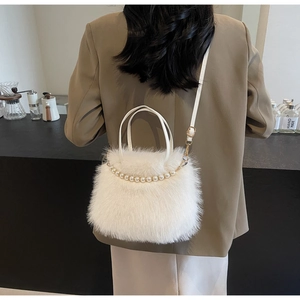 Dettaglio della borsa a secchiello in peluche bianca con perle e manico in pelle