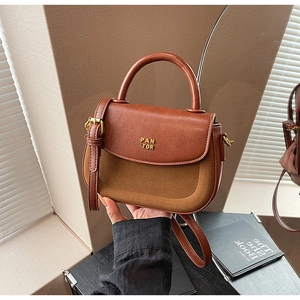Close-up of contrast texture brown leather and suede handbag with gold metal logo