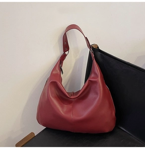 Nahaufnahme der dunkelroten Hobo-Tasche aus Leder mit Metallschließe auf einem Stuhl
