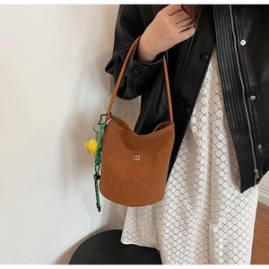 Braune Wildleder-Beuteltasche mit Goldlogo und niedlichem Enten-Anhänger