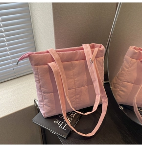 Detailed close-up of pink quilted puffer tote bag with metal ring and zip closure