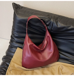 Detailaufnahme der dunkelroten Hobo-Tasche aus Leder mit Lychee-Narbung und Metallreißverschluss