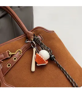 Detail eines Baseball-Schlüsselanhängers mit Schläger und Handschuh an einer Tasche