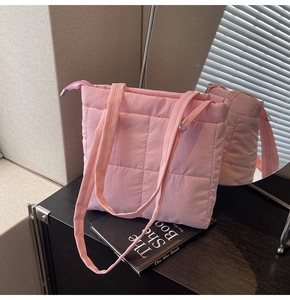 Detail of pink quilted tote bag showing plush feather texture and silver zipper closure