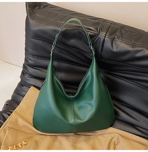 Makroaufnahme einer dunkelgrünen Hobo-Tasche aus Leder mit breitem Schultergurt