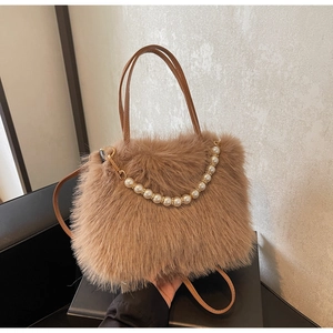 Dettaglio borsa a secchiello in peluche con catena di perle e tracolla in pelle fine