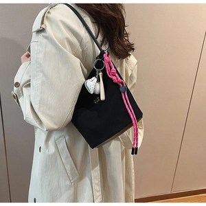 Detailansicht der schwarzen matten Beuteltasche mit rosa Kordel und Baseball-Anhängern