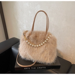 Dettaglio della borsa a secchiello in peluche con ecopelliccia e catena di perle eleganti