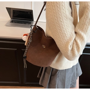 Braune mattierte Wildlederbeuteltasche mit goldenem Logo und Baseball-Anhänger