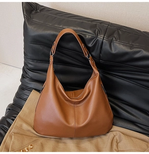 Detailansicht der braunen Hobo-Tasche aus genarbtem Leder mit dickem Trageriemen und Metall