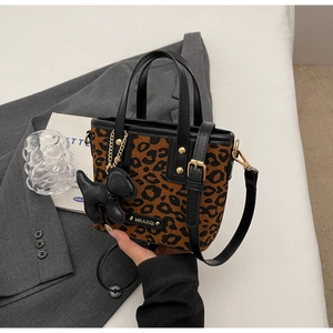 Détail du sac seau léopard avec bordure en cuir noir et breloque chiot mignonne
