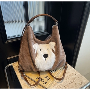 Detail of brown corduroy bag showing plush dog pattern texture and leather strap