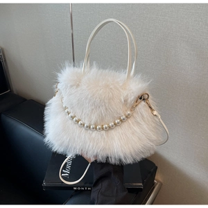 Dettaglio borsa a secchiello in peluche bianca con catena di perle e finiture dorate