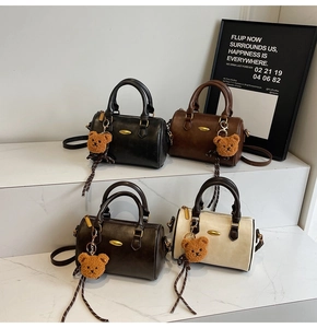 Classic Boston handbags in four colors with cute bear charms on marble steps